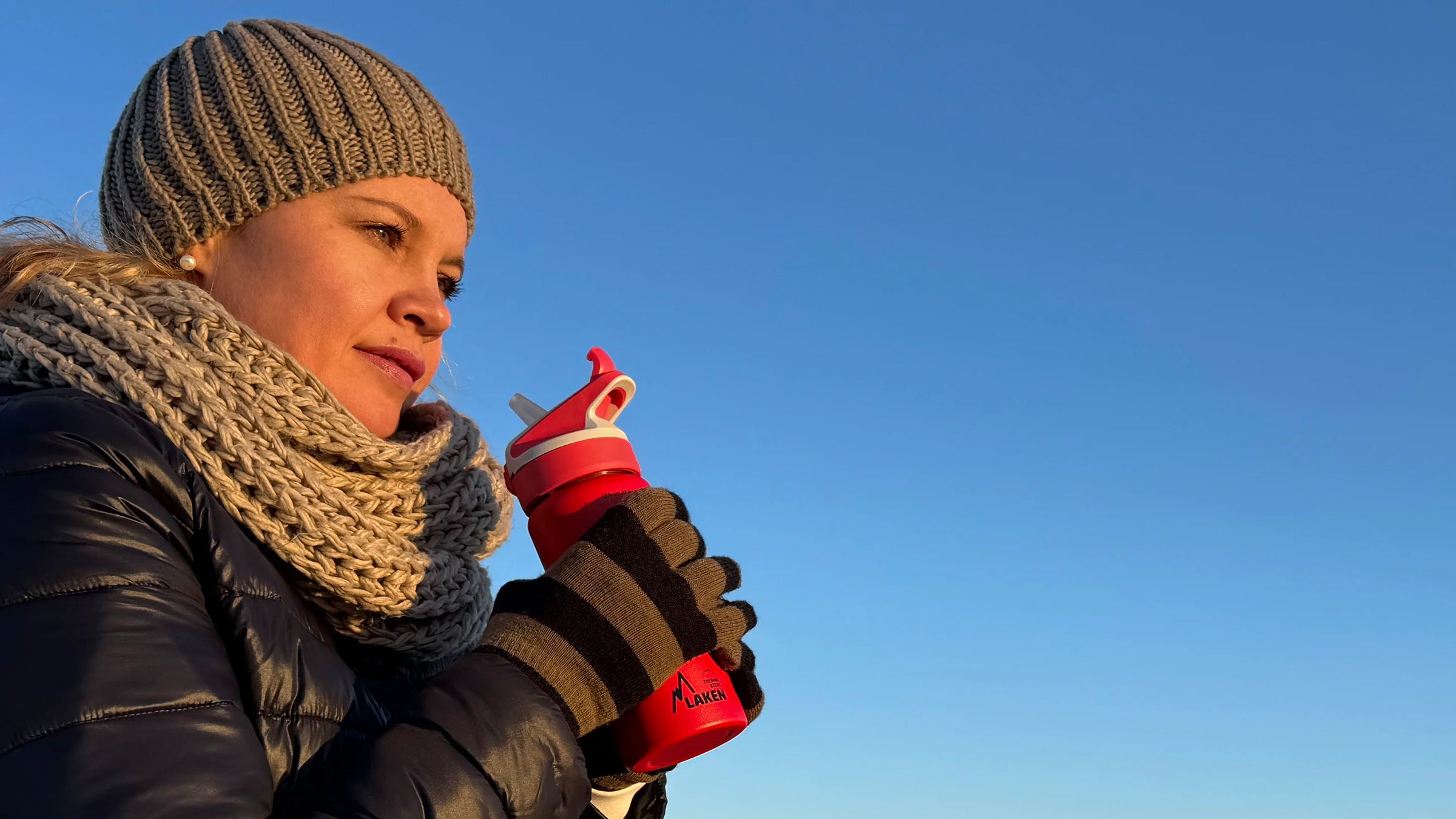 Mujer sosteniendo una botella LAKEN térmica roja con tapón SUMMIT