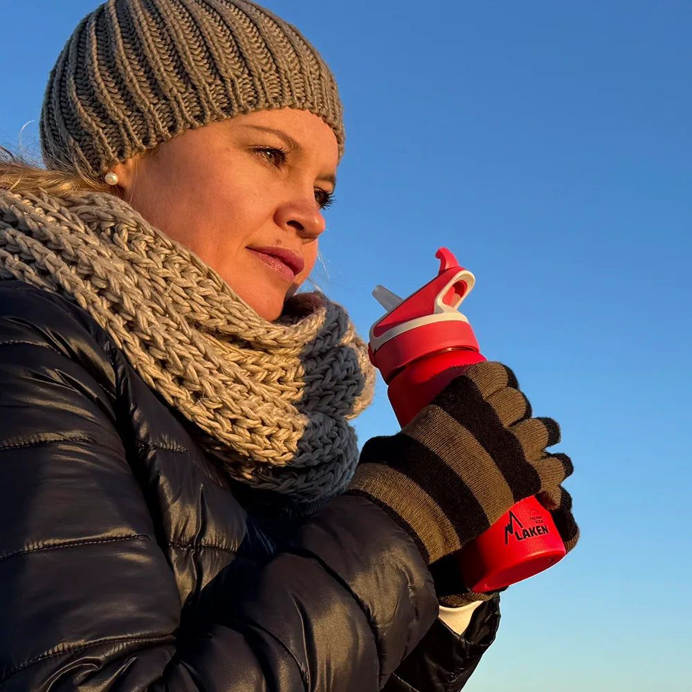 Mujer sosteniendo una botella LAKEN térmica roja con tapón SUMMIT