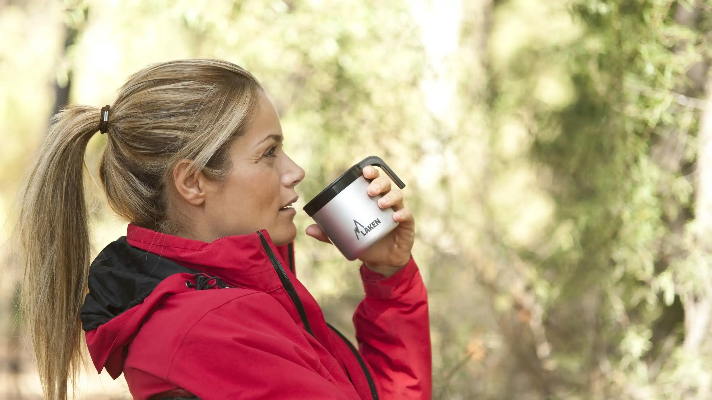 Mujer bebiendo en una taza de aluminio LAKEN